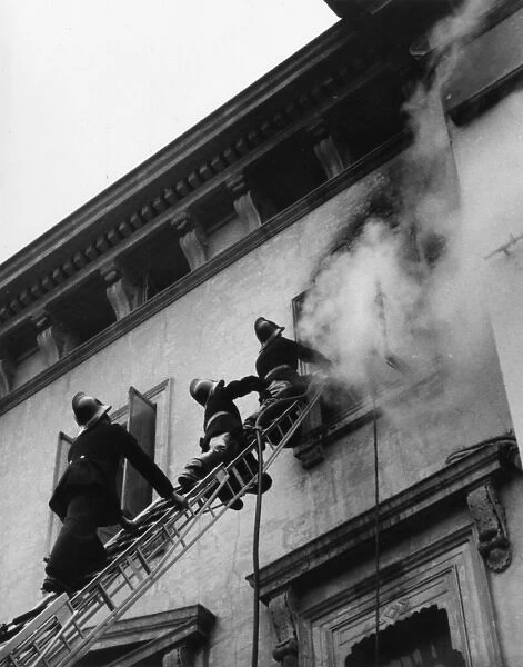 Firefighters in action up a ladder