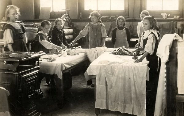 Young girls ironing in laundry room, Surrey