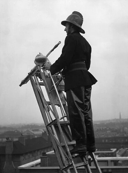 Firefighter using hook belt at top of ladder