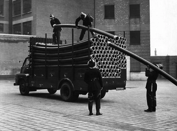 LFB firefighters unloading piping from a vehicle