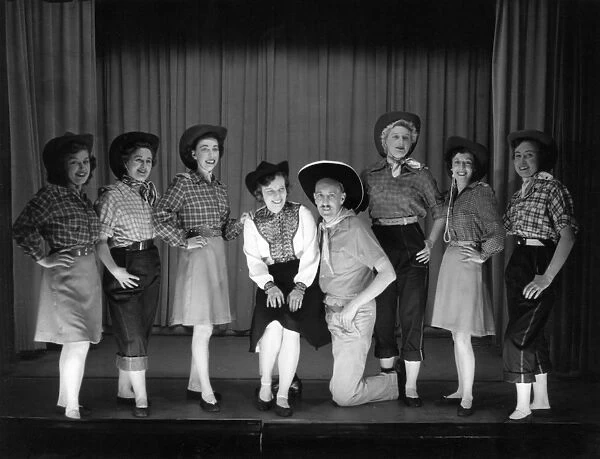 Seven women and a man in cowboy costume