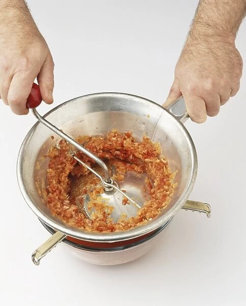 Blended red pepper mix being put through sieve (making red pepper ketchup)