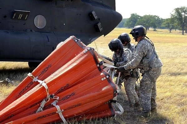 CH-47 Chinook helicopter crew prepare to install the Bambi Bucket on the aircraft
