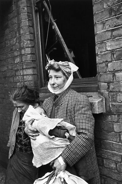 Mother holding her baby outisde her home on Bethnal Green