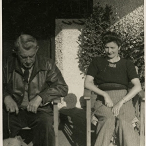 Couple in garden chairs with two dogs