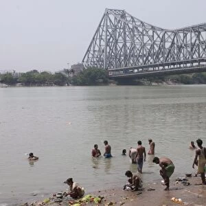 People washing in the River, Howrah Bridge in background, Kolkata, West Bengal