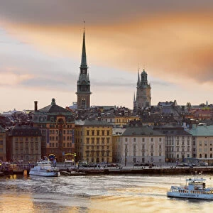 Sweden, Stockholm, Riddarfjarden, Gamla Stan; passenger ferries in bay at dusk