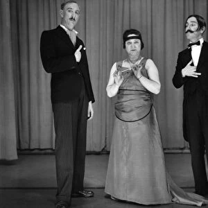 Two men and a woman performing in a comic sketch