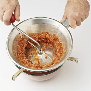 Blended red pepper mix being put through sieve (making red pepper ketchup)