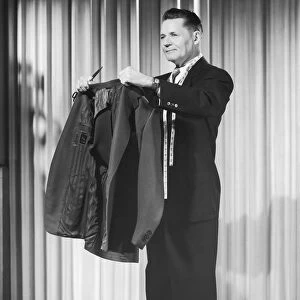 Tailor holding up suit jacket
