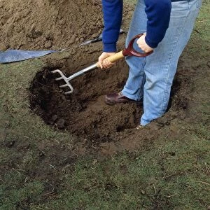 Using garden fork to scarify inside wall of hole in ground
