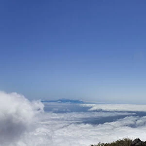 Young man looking across a layer of clouds, La Palma, Canary Islands, Spain