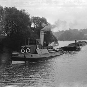 A tug tows barges on the river Thames near Richmond upon Thames. 1936