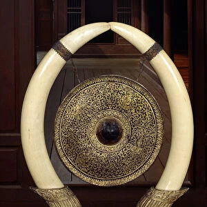 A gong hanging from elephant tusks (metal & ivory)