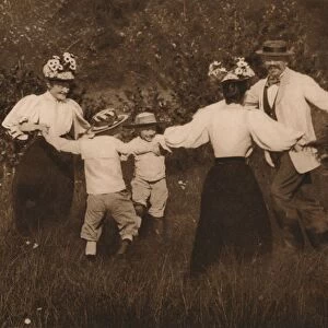 Family playing games in a field, 1937